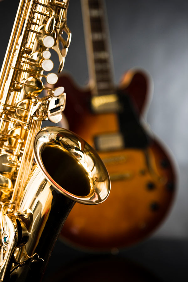 A saxophone sitting in front of a guitar