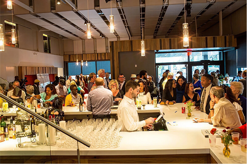 Bartender behind the bar with event crowd