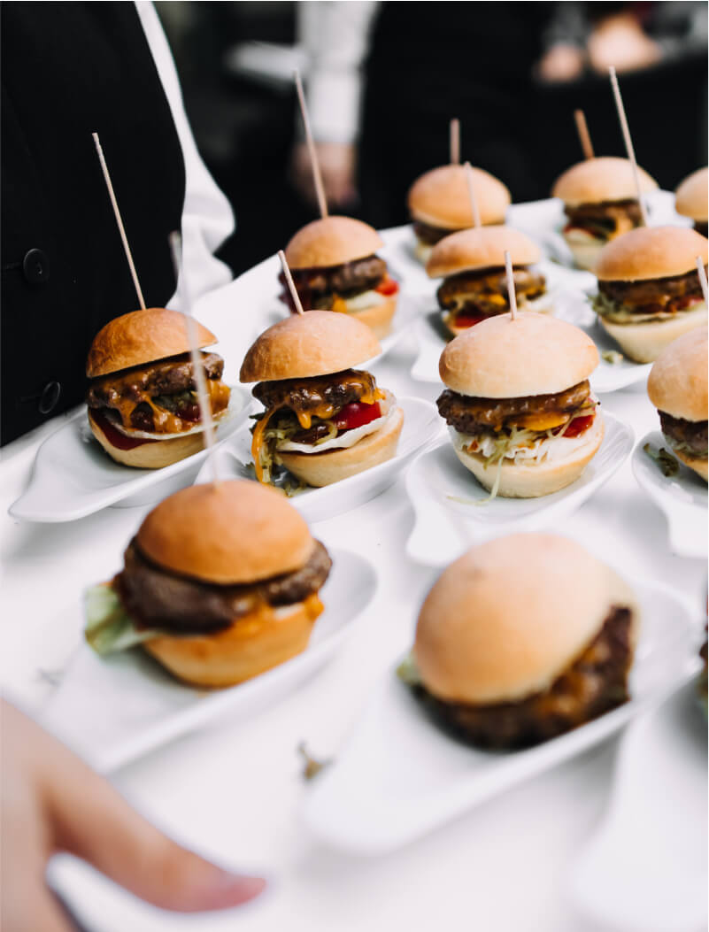 server with hamburger sliders on a tray